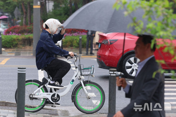 [서울=뉴시스] 권창회 기자 = 백곡을 기름지게 하는 봄비가 내린다는 절기상 '곡우(穀雨)'인 지난 20일 서울 중구 서울시의회 인근에서 우산을 챙기지 못한 시민이 손수건으로 비를 피하고 있다. 2026.04.20. kch0523@newsis.com