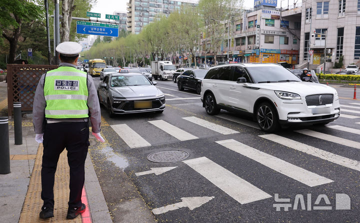[서울=뉴시스] 황준선 기자 = 20일 서울 강남구 대치역 사거리에서 경찰이 우회전 일시 정지 의무 위반 차량에 대한 집중 단속을 하고 있다.경찰청은 지난 2023년 도입된 우회전 일시정지 제도를 현장에 안착시켜 우회전 사고에 취약한 보행자 안전을 확보하기 위해 이날부터 오는 6월 19일까지 2개월간 우회전 통행방법 위반에 대해 집중단속을 실시한다고 밝혔다. 2026.04.20. hwang@newsis.com