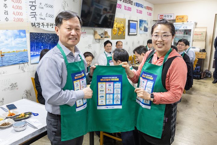 [세종=뉴시스]한국서부발전은 20일 본사가 있는 충남 태안군 일대에서 지역 식당과 함께하는 에너지절약 실천 캠페인을 추진했다. 사진은 이정복 서부발전 사장(왼쪽)과 지역 상인이 기념 촬영하는 모습이다.(사진=한국서부발전 제공) *재판매 및 DB 금지