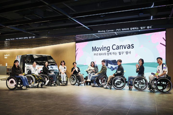 [서울=뉴시스] 지난 20일 경기 평택에 위치한 PBV 익스피리언스 센터에서 진행된 '무빙 캔버스 - PV5 WAV와 함께하는 휠꾸(휠체어 꾸미기)' 행사 참가자들이 기념촬영을 하고 있다. (사진=기아 제공) 2026.4.21. photo@newsis.com *재판매 및 DB 금지