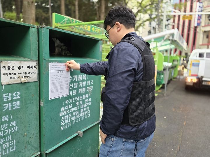 [제주=뉴시스] 제주시 관계자가 무단 설치된 의류수거함에 행정대집행을 예고하는 계고장을 붙이고 있다. (사진=제주시 제공) 2026.04.21. photo@newsis.com *재판매 및 DB 금지