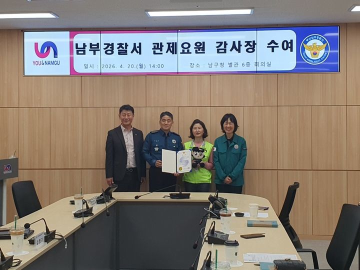 [부산=뉴시스] 시민 안전에 기여한 공을 인정받아 경찰 감사장을 받은 부산 남구청 소속 CCTV 관제센터요원 허윤정씨(왼쪽에서 세 번째). (사진=남구청 제공) 2026.04.21. photo@newsis.com *재판매 및 DB 금지