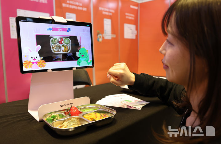 [서울=뉴시스] 최진석 기자 = 21일 서울 강남구 코엑스에서 열린 2026 우수급식외식산업전에서 한 관계자가 AI푸드 스캐너를 이용해 식판을 촬영하고 있다. 2026.04.21. myjs@newsis.com