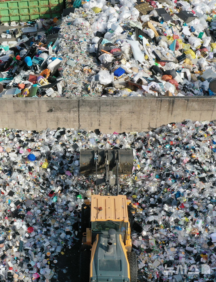 [수원=뉴시스] 김종택기자 = 지구의 날을 하루 앞둔 21일 경기 수원시 영통구 수원시자원순환센터에서 관계자들이 각 가정에서 쏟아져 나온 플라스틱 재활용 쓰레기를 처리작업 하고 있다. 2026.04.21. jtk@newsis.com