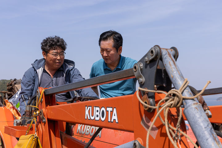 [서울=뉴시스] 조성봉 기자= 정청래 더불어민주당 대표가 21일 오후 경남 통영 욕지도 한 고구마 재배 현장을 찾아 농민과 프론트로더가 장착된 농업용 트랙터를 타고 대화를 하고 있다.(사진=더불어민주당 제공)2026.04.21. photo@newsis.com *재판매 및 DB 금지