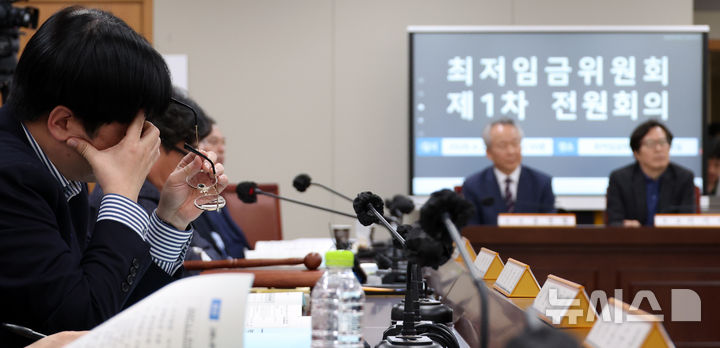 [세종=뉴시스] 강종민 기자 = 21일 세종시 정부세종청사에서 열린 최저임금위원회 1차 전원회의.   민주노총 위원들이 권순원 신임 위원장 선출에 반발하며 퇴장하 자리에 있던 위원들이 피곤한 듯 얼굴을 만지고 있다. 2026.04.21. ppkjm@newsis.com