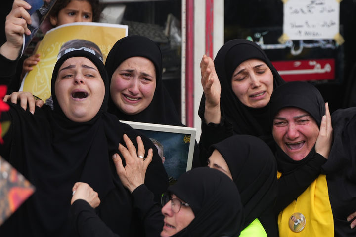 [크파르 시르( 레바논)=AP/뉴시스] 레바논의 헤즈볼라 전사자 합동 장례식이 열린 4월 21일 크파르 시르 시내에서 노란 색 레바논 국기로 덮인 관들이 대형 트럭들에 실린 채 울부짖는 유족들과 군중의 앞을 통과하고 있다. 2026. 04. 22.&nbsp; 