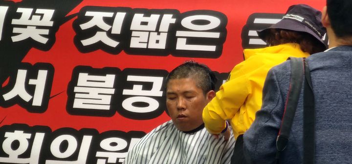 [창원=뉴시스]22일 국민의힘 경남도당 앞에서 함안군민이 함안군수 후보 경선에 항의하면서 삭발식을 하고 있는 모습. 2026.04.22.sky@newsis.com *재판매 및 DB 금지