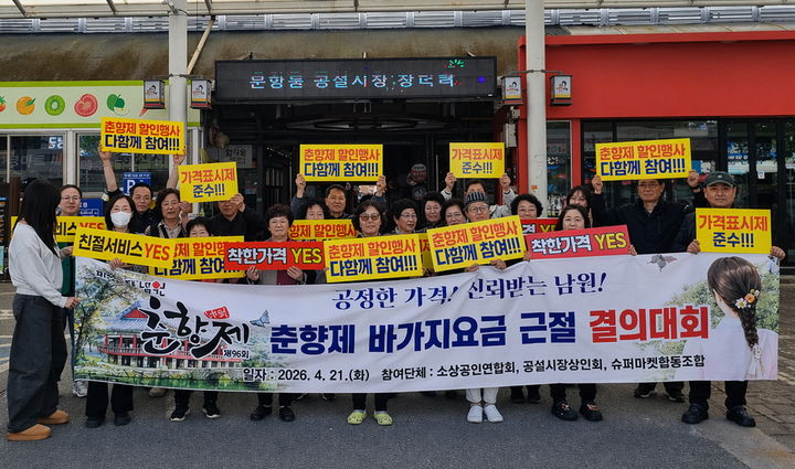 [남원=뉴시스] 지난 21일 열린 남원시 소상공인연합회, 슈퍼마켓협동조합, 공설시장상인회 등 상인단체 회원들의 '춘향제 바가지요금 근절 결의대회', 상인들이 바가지요금 근절 및 춘향제 할인행사 등의 내용이 담긴 현수막 등과 함께 사진을 찍고 있다. *재판매 및 DB 금지