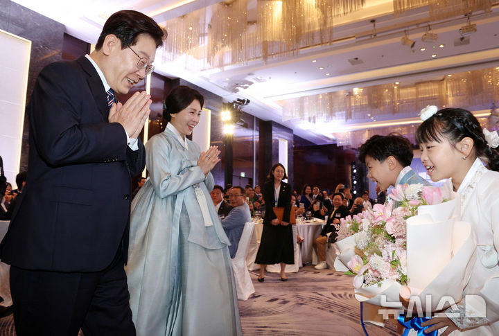 [하노이=뉴시스] 고범준 기자 = 베트남을 국빈 방문 중인 이재명 대통령과 김혜경 여사가 22일(현지 시간) 하노이 한 호텔에서 열린 동포 오찬 간담회에서 화동과 인사하고 있다. 2026.04.22. bjko@newsis.com