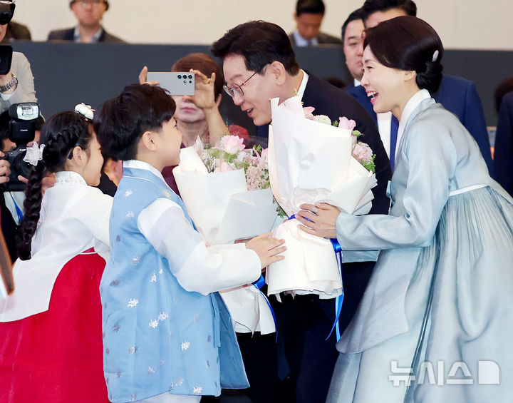 [하노이=뉴시스] 고범준 기자 = 베트남을 국빈 방문 중인 이재명 대통령과 김혜경 여사가 22일(현지 시간) 하노이 한 호텔에서 열린 동포 오찬 간담회에서 화동들에게 꽃다발을 받고 있다. 2026.04.22. bjko@newsis.com