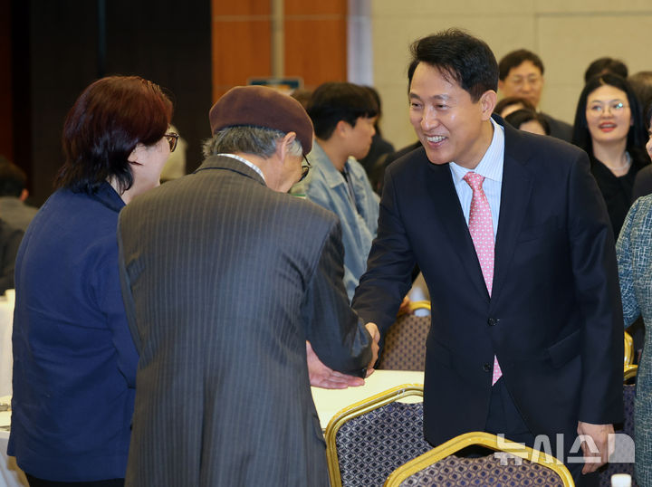 [서울=뉴시스] 배훈식 기자 = 오세훈 서울시장이 22일 오후 서울 용산구 백범김구기념관에서 열린 서울시사회복지사협회 창립 40주년 기념행사 참석자들과 악수하고 있다. 2026.04.22. dahora83@newsis.com
