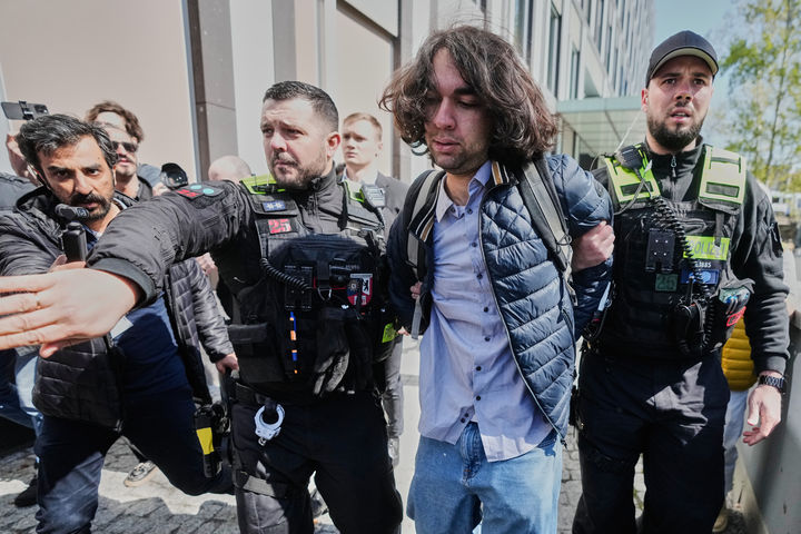 [베를린=AP/뉴시스] 레자 팔레비 전 이란 왕세자가 23일(현지 시간) 독일 베를린에서 미국과 이란의 휴전을 비난하는 기자회견 이후 붉은 액체 테러를 당한 가운데 경찰이 해당 사건 용의자를 체포해 연행하고 있다. 2026.04.24.