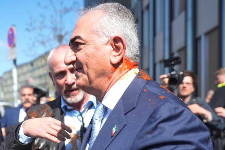 [베를린=AP/뉴시스]샤 레자 팔라비 전 이란 국왕의 아들로 망명 중인 레자 팔라비 전 이란 왕세자가ㅜ23일 독일 베를린에서 미국과 이란 간 휴전을 비난하는 기자회견을 마치고 떠나려다 붉은 액체를 뒤집어쓰는 공격을 받았다. 팔라비가 공격 후 보호를 받으며 현장을 떠나는 모습. 2026.04.23.