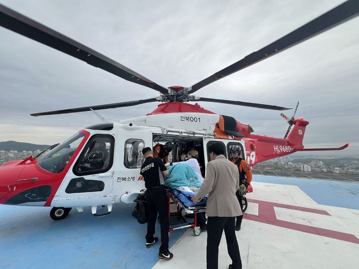 [세종=뉴시스] 지난 20일 전북 전주에서 조기 진통이 발생한 24주 고위험 임산부를 안전하게 이송하기 위해 총 360km를 비행한 전북 1호 소방헬기가 , 인천 가천대 길병원 옥상 헬리패드에 착륙해 대기 중이던 의료진에게 환자를 무사히 인계하고 있다. (사진=소방청) *재판매 및 DB 금지