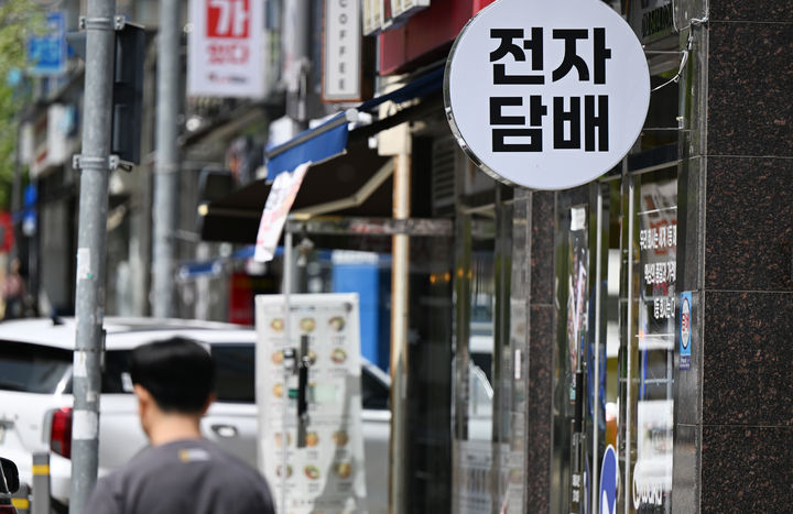 [광주=뉴시스] 박기웅 기자 = 합성니코틴 액상에 세금을 부과하는 담배사업법 개정안 시행을 하루 앞둔 23일 오후 한 시민이 광주 광산구 전자담배 판매업소 앞을 지나가고 있다. 2026.04.23. pboxer@newsis.com *재판매 및 DB 금지