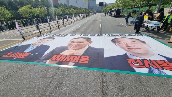 [평택=뉴시스] 이지용 기자 = 23일 23일 경기 평택시 고덕동 삼성전자 평택캠퍼스에서 열린 삼성전자 노동조합 공동투쟁본부 '4·23 투쟁 결의대회'에서 이재용 삼성전자 회장, 전영현 삼성전자 대표이사 부회장, 노태문 삼성전자 사장의 사진 현수막이 바닥에 놓였다. 2026.04.23. photo@newsis.com *재판매 및 DB 금지