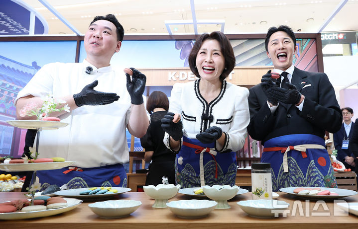 [하노이=뉴시스] 고범준 기자 = 김혜경 여사가 23일(현지 시간) 베트남 하노이 서호 롯데몰에서 열린 K-문화관광대전에서 배우 정일우, 지준혁 셰프와 마카롱을 들고 포즈를 취하고 있다. 2026.04.23. bjko@newsis.com