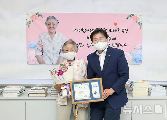 [시흥=뉴시스] 고 이옥순 할머니가 지난 2021년 농사일과 폐지 수집 등으로 평생 모은 1억원을 임병택 시장을 통해 시흥시에 기탁하고 있다. (사진=뉴시스 DB). photo@newsis.com