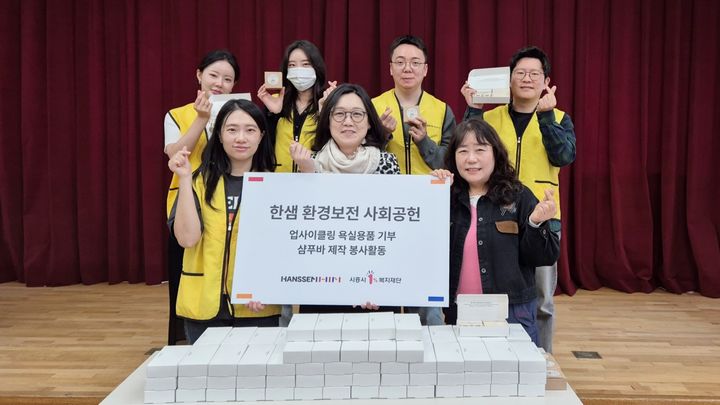 [서울=뉴시스] 지난 23일 친환경 샴푸바 제작 봉사활동에 참여한 한샘 임직원들이 시흥시가족센터 김한나 센터장(앞줄 가운데)과 기념 사진을 촬영하고 있다. (사진=한샘 제공) 2026.04.24. photo@newsis.com *재판매 및 DB 금지