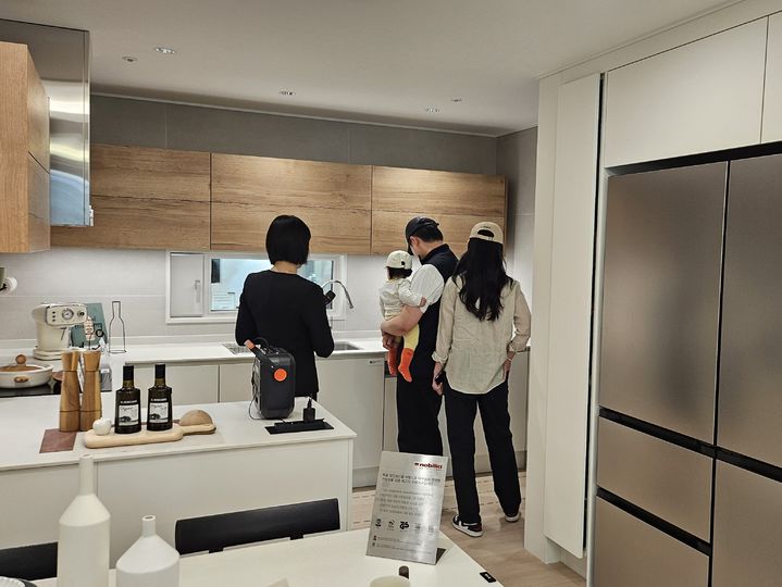 [서울=뉴시스] 김여림 인턴기자. 어린 자녀를 동반한 30대 부부가 공덕역자이르네 59㎡형 주방을 살펴보고 있다. 2026.04.24 *재판매 및 DB 금지