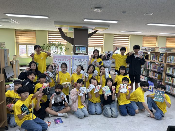 [울산=뉴시스] 울산초 학생들이 20일 도서관에서 책 한 입 사탕 한 입 행사를 하고 기념사진을 찍고있다. (사진=울산시교육청 제공) photo@newsis.com *재판매 및 DB 금지