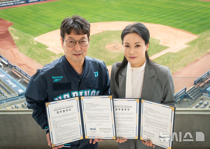 [창원=뉴시스]경남문화예술진흥원 박희영(오른쪽) 콘텐츠산업본부장이 지난 22일 창원 NC파크에서 프로야구단 NC 다이노스 손성욱 경영본부장과 경남 음악산업 및 스포츠 산업 발전을 위한 업무협약을 체결한 후 기념촬영하고 있다.(사진=경남문화예술진흥원 제공) 2026.04.24. photo@newsis.com