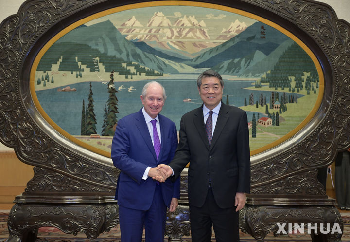 [베이징=신화/뉴시스] 허리펑 중국 국무원 부총리가 23일 베이징 인민대회당에서 사모펀드 운용사 블랙스톤의 스티븐 슈워츠먼 회장 겸 최고경영자(CEO)와 만나 악수하고 있다. 2026.04.24