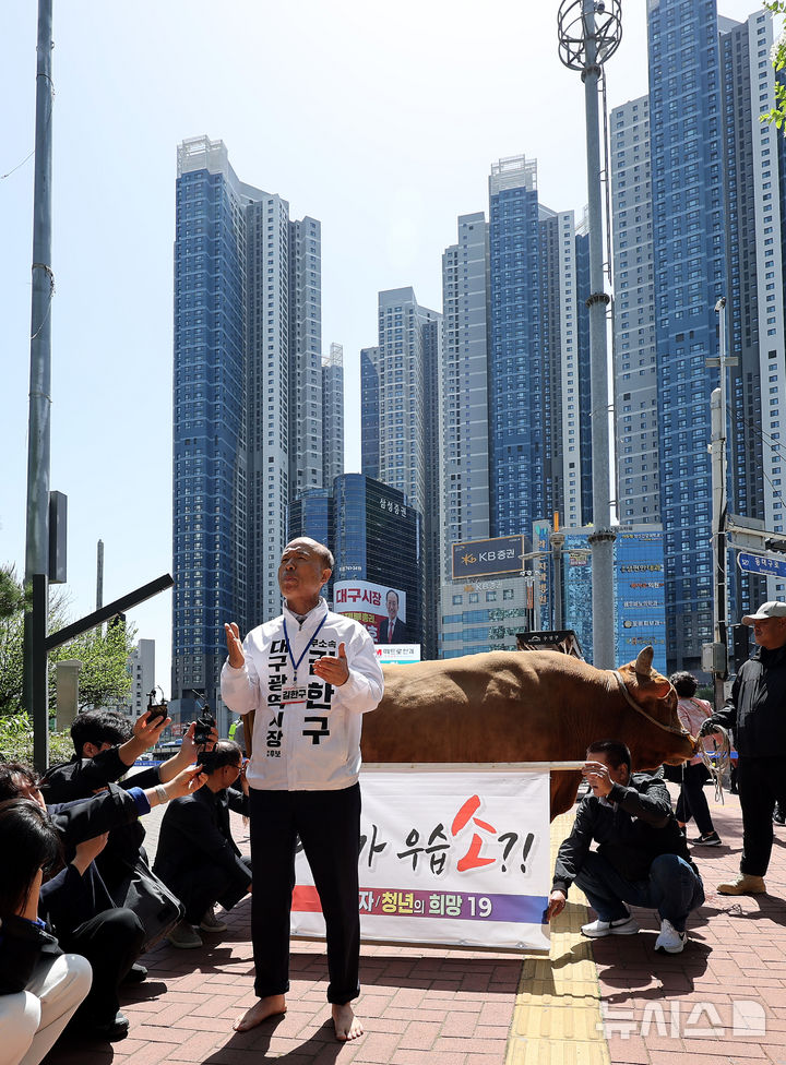 [대구=뉴시스] 이무열 기자 = 김한구 무소속 대구시장 예비후보가 24일 대구 수성구 범어네거리 인근에서 맨발로 소를 끌고 나와 기자회견을 하고 있다. 2026.04.24. lmy@newsis.com