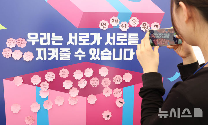 [서울=뉴시스] 조수정 기자 = 24일 오전 서울 종로구 청계광장에 마련된 한국자살예방협회 '천명지킴 발대식' 부스에서 시민들이 응원 문구를 작성해 붙인 뒤 촬영하고 있다. 2026.04.24. chocrystal@newsis.com