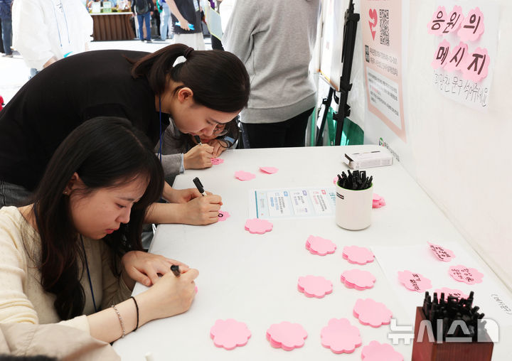 [서울=뉴시스] 조수정 기자 = 24일 오전 서울 종로구 청계광장에 마련된 한국자살예방협회 '천명지킴 발대식' 부스에서 시민들이 응원 문구를 작성하고 있다. 2026.04.24. chocrystal@newsis.com