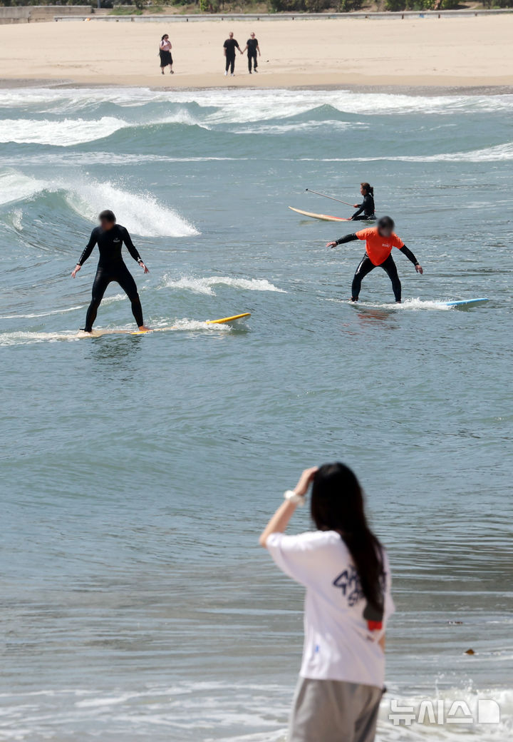  [부산=뉴시스] 하경민 기자 = 포근한 날씨를 보인 24일 부산 해운대구 송정해수욕장에서 서퍼들이 높은 파도를 즐기고 있다. 2026.04.24. yulnetphoto@newsis.com