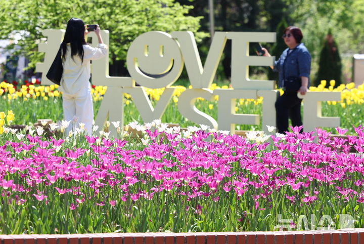 [고양=뉴시스] 황준선 기자 = 24일 경기 고양시 일산호수공원에서 개막한 2026 고양국제꽃박람회를 찾은 관람객들이 꽃을 관람하고 있다.  2026.04.24. hwang@newsis.com