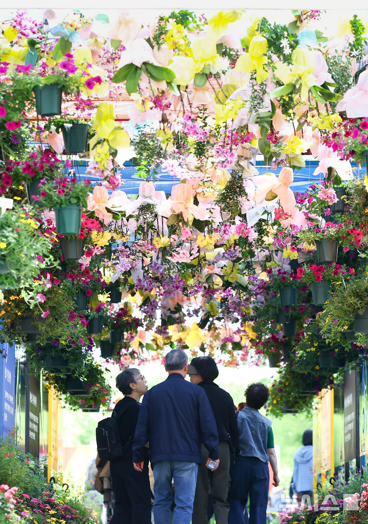 [고양=뉴시스] 황준선 기자 = 24일 경기 고양시 일산호수공원에서 개막한 2026 고양국제꽃박람회를 찾은 관람객들이 꽃을 관람하고 있다.  2026.04.24. hwang@newsis.com