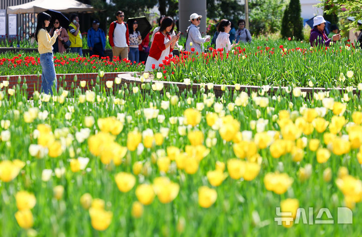 [고양=뉴시스] 황준선 기자 = 24일 경기 고양시 일산호수공원에서 개막한 2026 고양국제꽃박람회를 찾은 관람객들이 꽃을 관람하고 있다.  2026.04.24. hwang@newsis.com