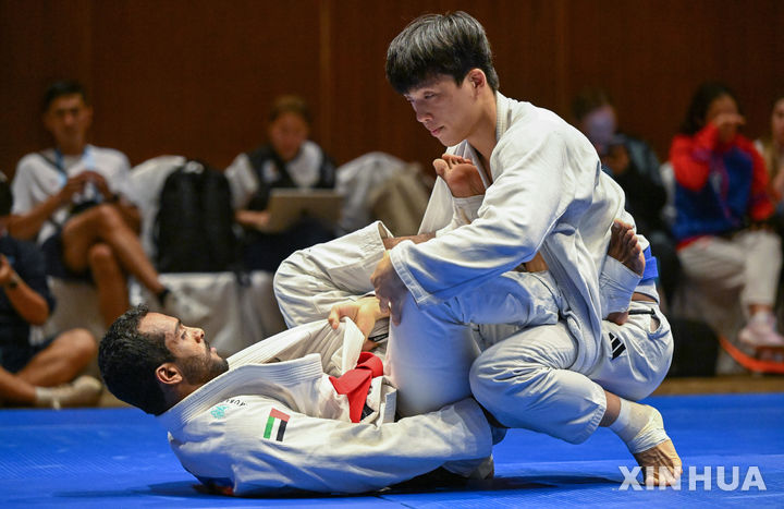 [산야=신화/뉴시스] 박재운(오른쪽)이 24일(현지 시간) 중국 하이난성 산야에서 열린 제6회 아시안 비치 게임(ABG) 주짓수 남자 77kg급 결승에서 마흐디 알라울라키(UAE)와 경기하고 있다. 박재운은 알라울라키와 2-2로 비겼으나 어드밴티지(8-2)로 우세승을 거두며 금메달을 목에 걸었다. 2026.04.25.