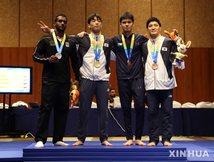 [산야=신화/뉴시스] 박재운(왼쪽 두 번째)와 구본철(오른쪽)이 24일(현지 시간) 중국 하이난성 산야에서 열린 제6회 아시안 비치 게임(ABG) 주짓수 남자 77kg급 금메달과 동메달을 따낸 후 시상대에 올라 포즈를 취하고 있다. 2026.04.25.