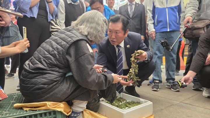 [세종=뉴시스] 송승화 기자 = 25일 조치원읍, 세종전통시장에서 상인에게 두릅 구매하는 정청래 더불어민주당 대표. 2026.04.25. ssong1007@newsis.com *재판매 및 DB 금지