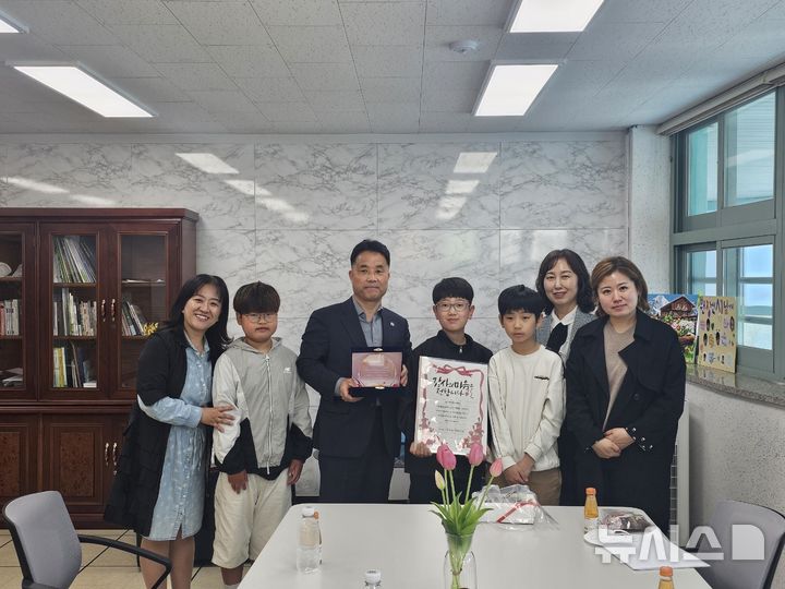 [시흥=뉴시스] ‘하트 편지’를 받은 박영칠 영석산업개발 대표(사진 왼쪽에서 세 번째)와 편지를 전달한 학생과 교사들이 환하게 웃으며, 기념 촬영을 하고 있다. (사진=시흥교육지원청 제공). 2026.04.26. photo@newsis.com