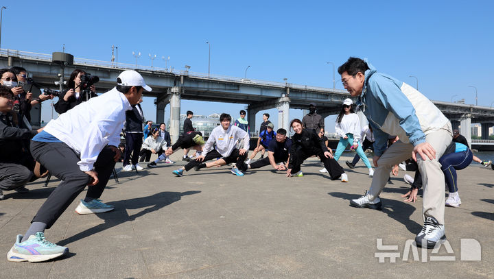 [서울=뉴시스] 이영환 기자 = 정원오 더불어민주당 서울시장 후보가 25일 오전 서울 서초구 잠수교 남단에서 열린 찾아가는 현장 : 러닝편에 참석해 러너들과 준비운동을 하고 있다. 2026.04.25. 20hwan@newsis.com