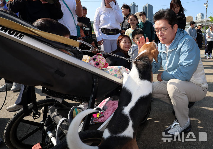 [서울=뉴시스] 이영환 기자 = 정원오 더불어민주당 서울시장 후보가 25일 오전 서울 서초구 잠수교 남단에서 열린 찾아가는 현장 : 러닝편에 참석해 한 러너의 반려견과 인사를 나누고 있다. 2026.04.25. 20hwan@newsis.com