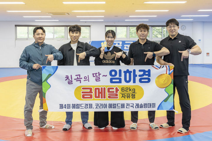 [칠곡=뉴시스] 왼쪽부터 박근용 칠곡군레슬링협회 경기이사, 아버지 임종구 씨, 임하경, 박노운 칠곡군레슬링협회 이사, 김재강 칠곡군청 레슬링 감독이 기념 촬영을 하고 있다. (사진=칠곡군 제공) 2026.04.26 photo@newsis.com *재판매 및 DB 금지