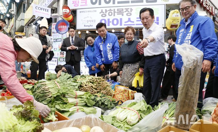 [단양=뉴시스] 이병찬 기자 = 26일 충북 단양 구경시장을 찾은 더불어민주당 정청래 대표가 난전에서 물건 값을 흥정하고 있다. 이날 정 대표의 현장 방문에는 같은 당 신용한 충북지사 후보와 김광직 단양군수 후보가 동행했다.2026.04.26.bclee@newsis.com 