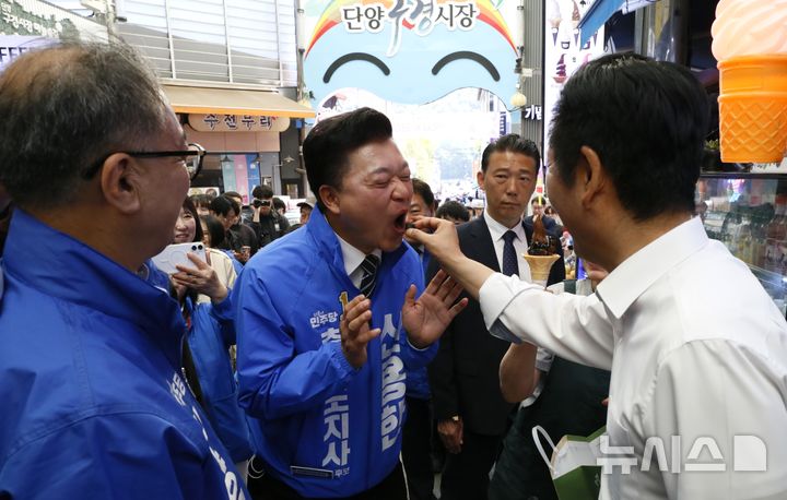 [단양=뉴시스] 이병찬 기자 = 26일 충북 단양 구경시장을 찾은 더불어민주당 정청래 대표가 신용한 충북지사 후보에게 젤리를 먹여주고 있다. 이날 정 대표의 현장 방문에는 같은 당 신 후보와 김광직 단양군수 후보가 동행했다.2026.04.26.bclee@newsis.com 