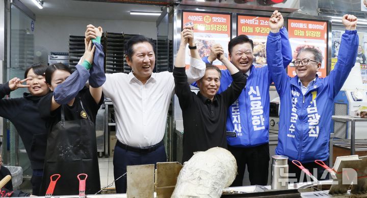[단양=뉴시스] 이병찬 기자 = 26일 충북 단양 구경시장을 찾은 더불어민주당 정청래 대표가 상인 가족과 두 손을 들어보이고 있다. 이날 정 대표의 현장 방문에는 같은 당 신용한 충북지사 후보와 김광직 단양군수 후보가 동행했다.2026.04.26.bclee@newsis.com