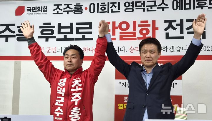[영덕=뉴시스] = 국민의힘 영덕군수 예비후보인 이희진 전 군수가 지난 16일 후보 경선 참여를 접고 조주홍 후보 지지를 선언한 후 함께 손을 들고 있다. (사진=조주홍 후보 선거사무소 제공) 2026.04.26. photo@newsis.com