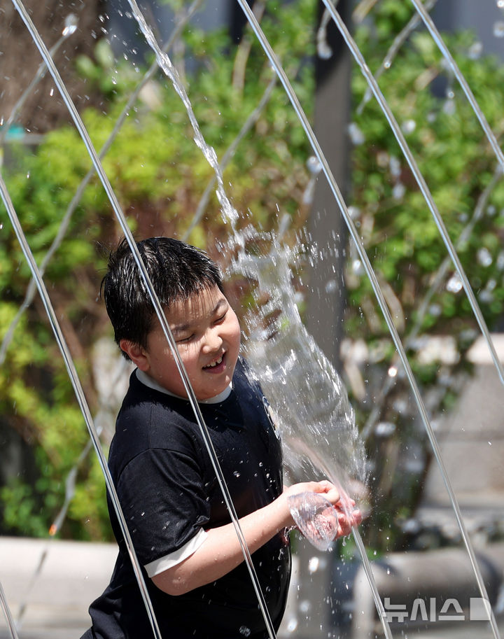 [서울=뉴시스] 추상철 기자 = 초여름 날씨를 보인 26일 오후 서울 종로구 광화문광장 분수대에서 어린이가 물놀이를 하고 있다. 2026.04.26. scchoo@newsis.com