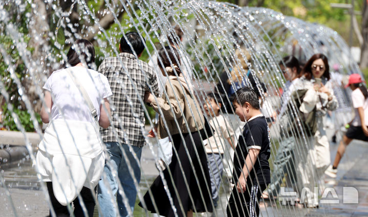 [서울=뉴시스] 추상철 기자 = 초여름 날씨를 보인 26일 오후 서울 종로구 광화문광장에서 시민들이 분수터널을 지나고 있다. 2026.04.26. scchoo@newsis.com