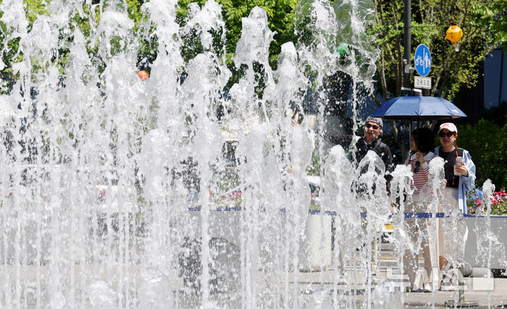 [서울=뉴시스] 추상철 기자 = 초여름 날씨를 보인 26일 오후 서울 종로구 광화문광장 분수대에서 외국인 관광객이 뿜어져 나오는 물줄기를 보고 있다. 2026.04.26. scchoo@newsis.com