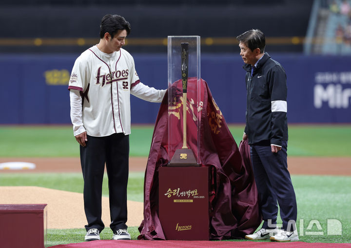 [서울=뉴시스] 홍효식 기자 = 박병호 키움 히어로즈 코치가 26일 서울 구로구 고척스카이돔에서 열린 2026 KBO 리그 삼성 라이온즈와 키움 히어로즈의 경기 전 은퇴식에서 키움 위재민 대표이사에게 기념 배트를 전달받고  있다. 2026.04.26. yesphoto@newsis.com